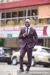 Man in purple suit standing on street 4AoP60