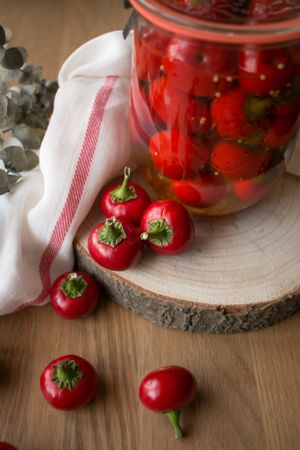 Pickled cherry peppers near napkin and twig