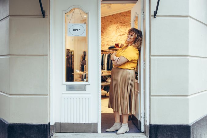 Businesswoman standing at the doorway of her boutique
