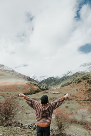 Young woman standing in a beautiful landscape between mountains