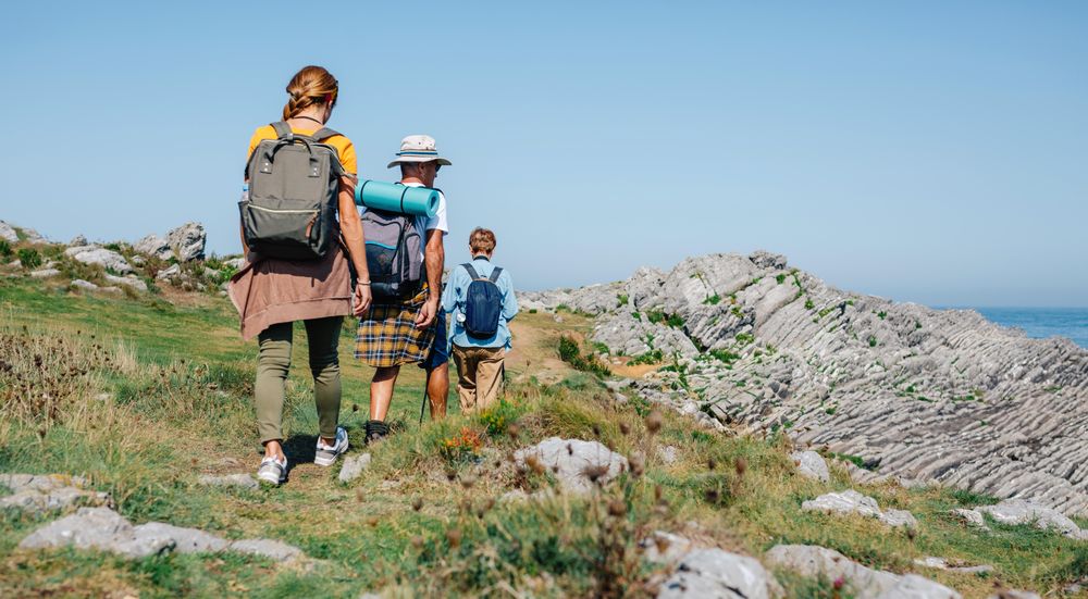 Group of people with hiking equipment walking outside
