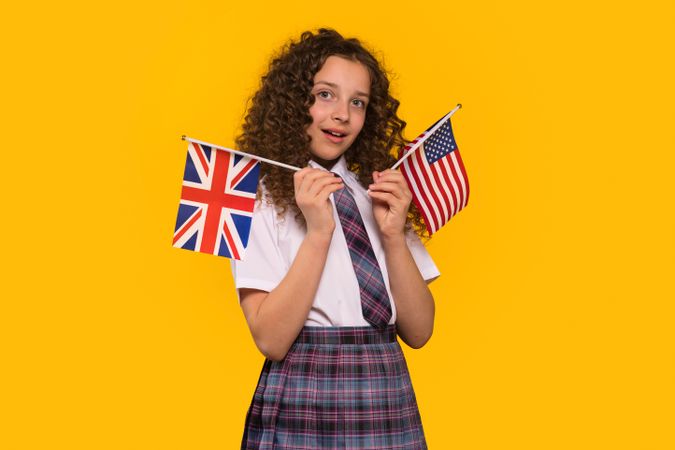 Girl holding USA and UK flags