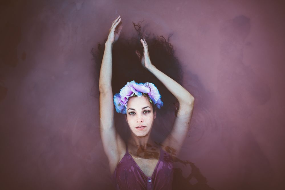 Woman with wreath lying in water