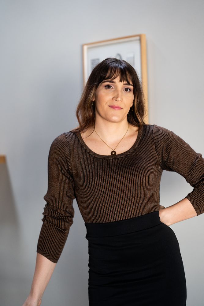 Transgender woman posing in office with hand on hip