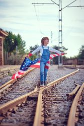 Happy boy celebrating USA Independence Day on railway