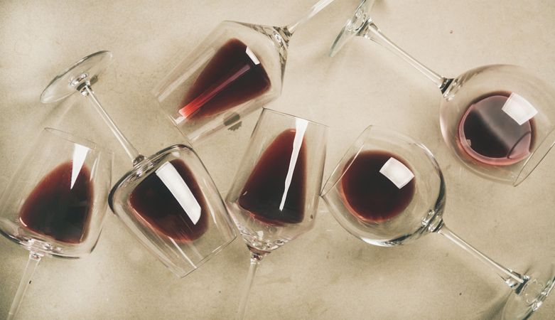 Glasses of red wine glasses laying on grey background