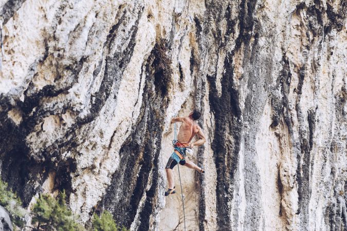 Anonymous man climbing rock