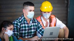 Construction workers reading plans on laptop together 4m1jv4