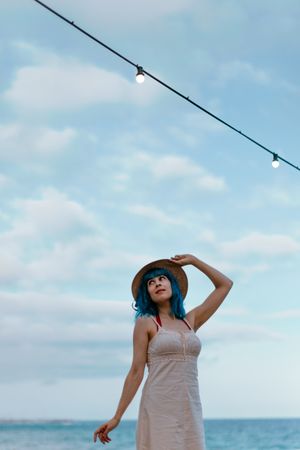 Charming woman in sundress walking along pier