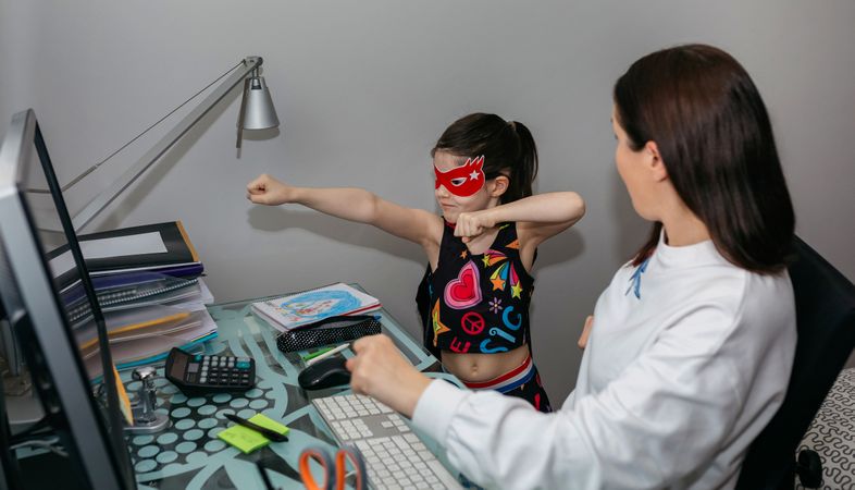 Woman teleworking and looking with her daughter