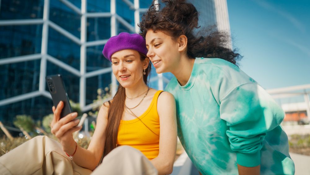 Two Young Women, One Wearing A Purple Hat And Yellow Top