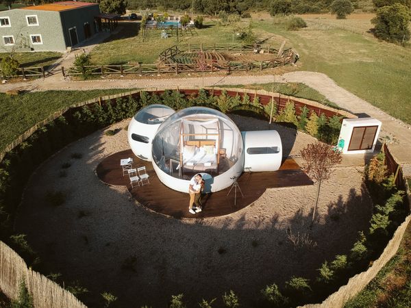 Young couple kissing by unusual bubble hotel