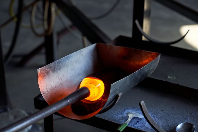 Blowpipe making glass base in workshop