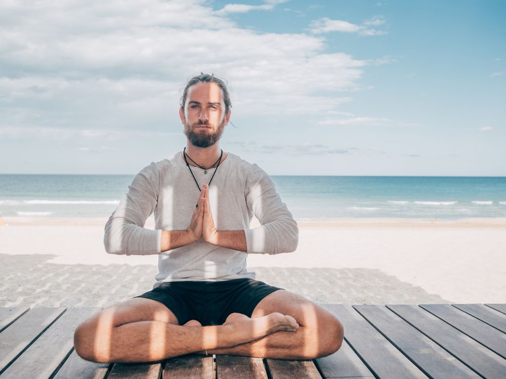 Man meditating on beach
