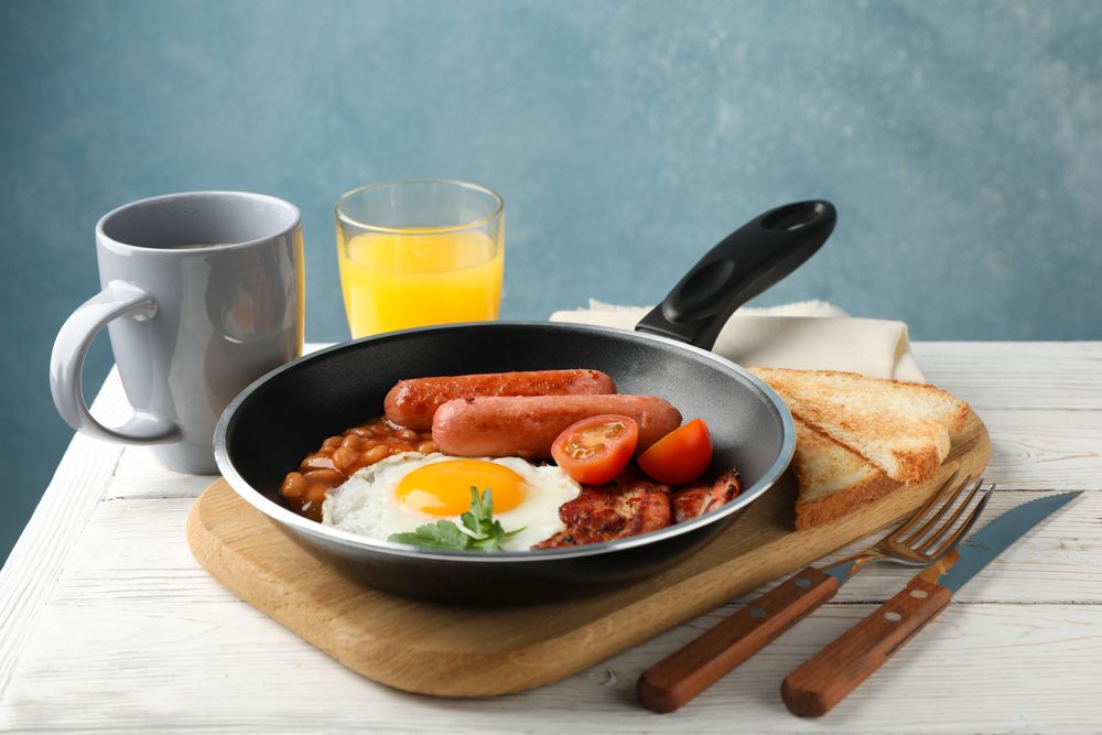 Pan of breakfast fry up against a blue background