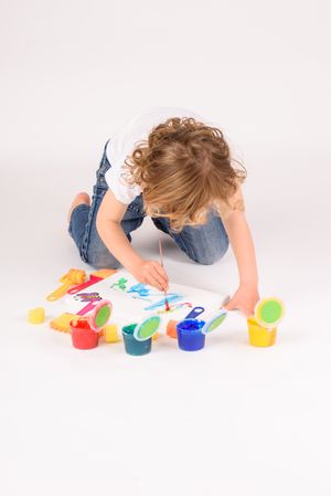 Faceless boy painting in studio