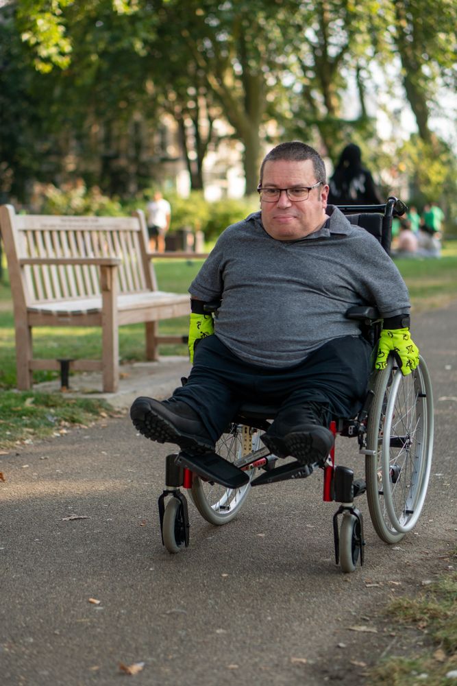 Man in wheelchair going through park