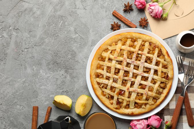 Composition with apple pie and ingredients on gray background, top view