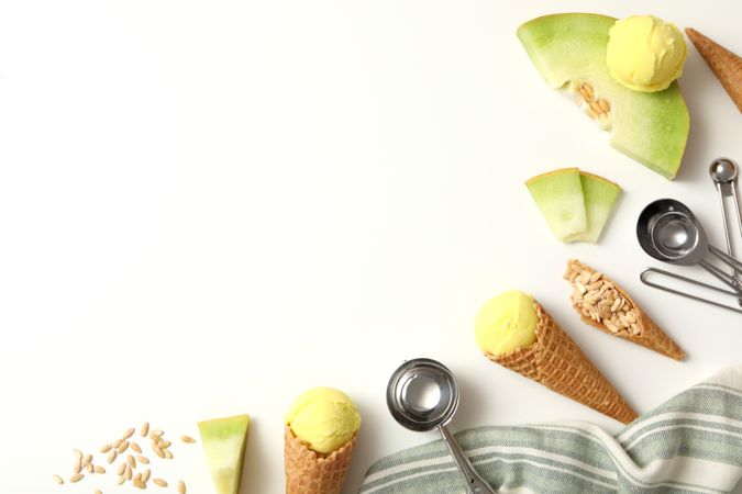 Ice cream cones with pieces of fresh melon on a plain background