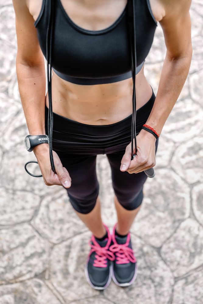 Woman posing with skipping rope in a park