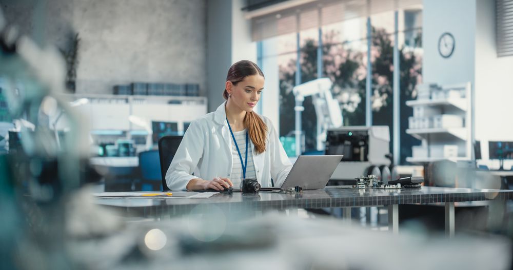 Portrait of Professional Female Scientist Working in Industrial Lab Using Laptop Computer.