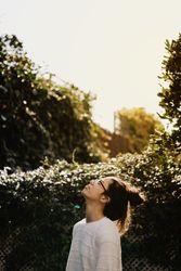 Young woman looking up in yard