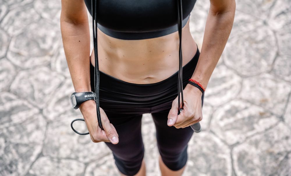 Woman posing with skipping rope in a park