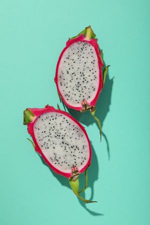Two half of dragon fruit on blue background, top view
