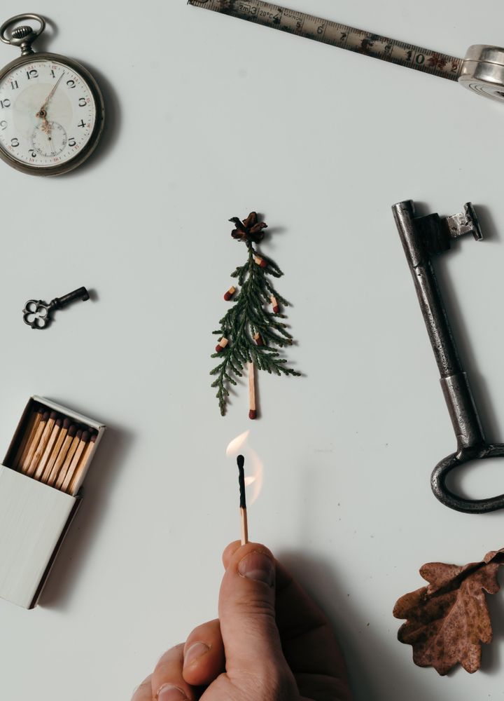 Creative arrangement of vintage items on desk with hand lighting match