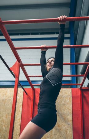 Sportswoman exercising on monkey bars