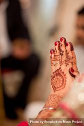 Indian bride's hand with henna tattoo on it 4mGJN0