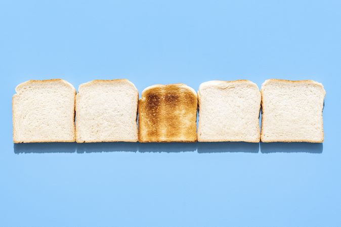 Slices of toast bread alligned in a row on a blue background