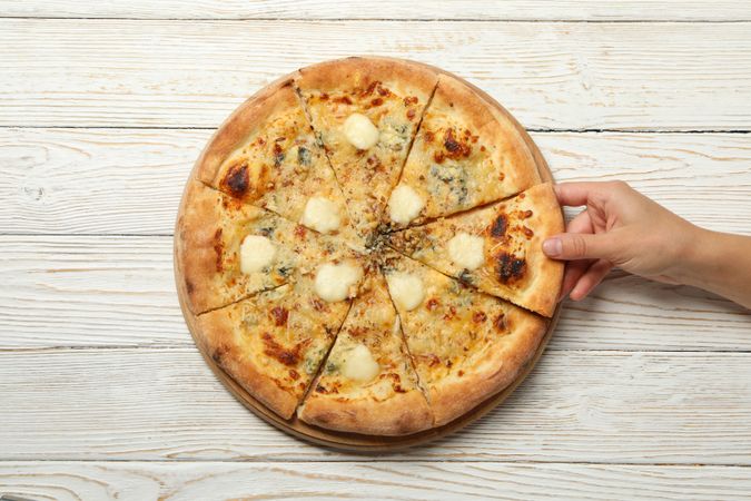 Female hand hold slice of tasty cheese pizza