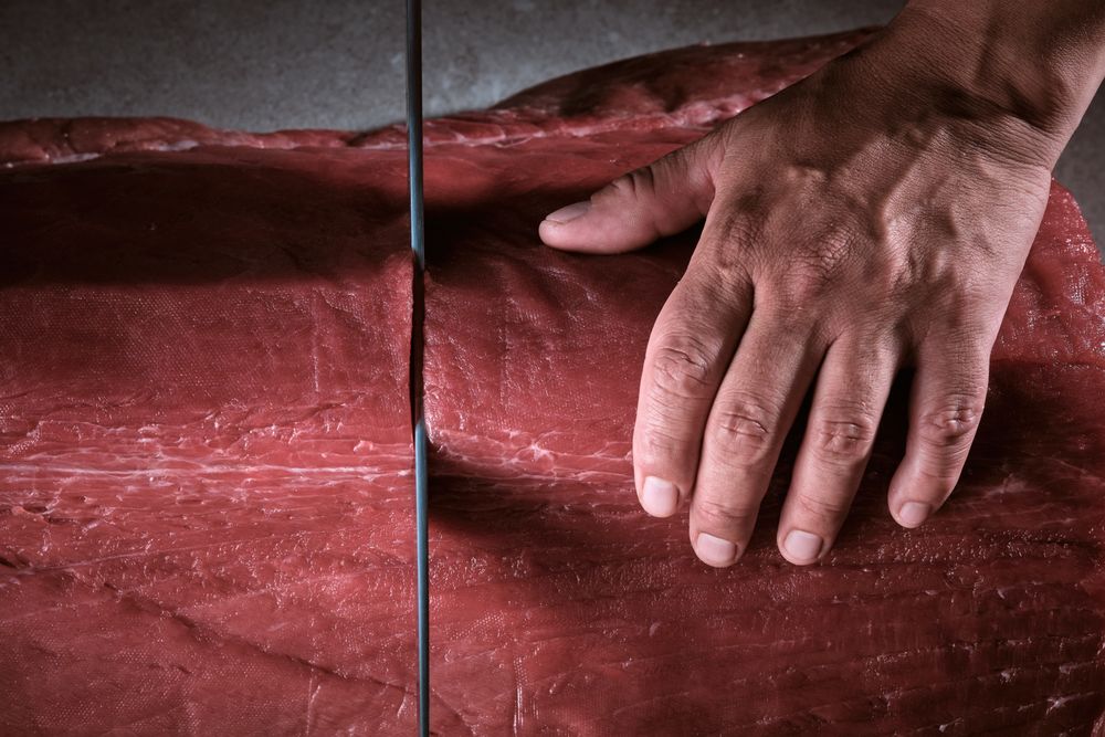 Male hands of a chef cutting a delicious loin of fresh bluefin t