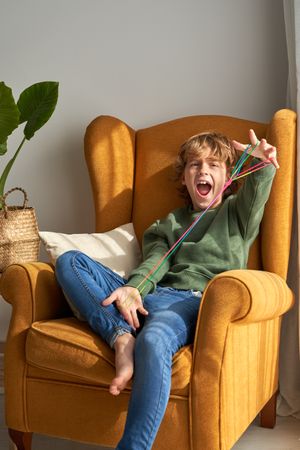 Excited boy playing with finger thread