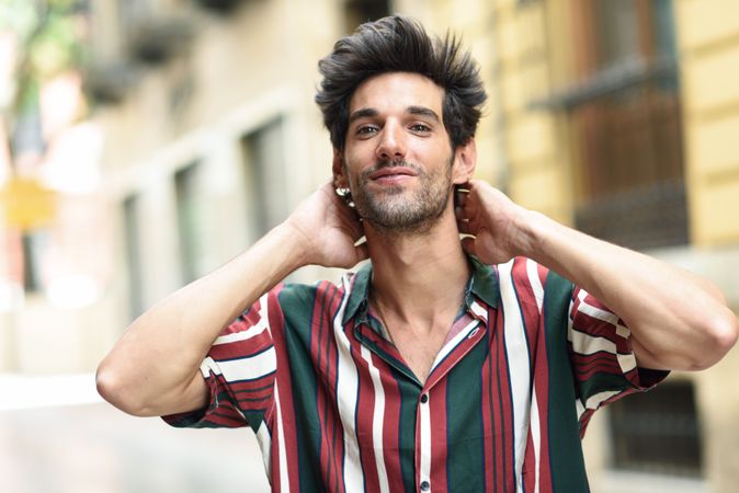 Portrait of confident dark haired man standing outside