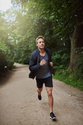 Muscular man running on a path in the park
