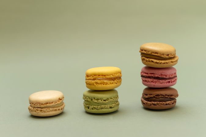 Three piles of colorful macaroons on a marble background