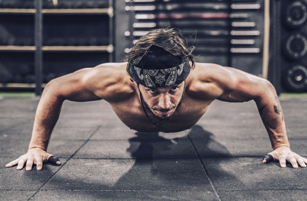 strong and athletic man doing push-up workout in modern gym