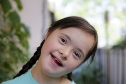 Beautiful little girl smiling with her head tilted wearing piggy tails