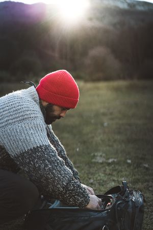 Photographer holding camera from backpack