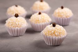 Close up of coconut or vanilla truffles with sprinkles on marble table