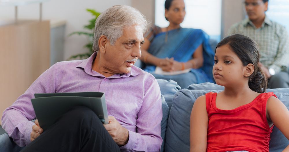 Girl Having a Conversation with Family Member While Waiting in Reception Hall