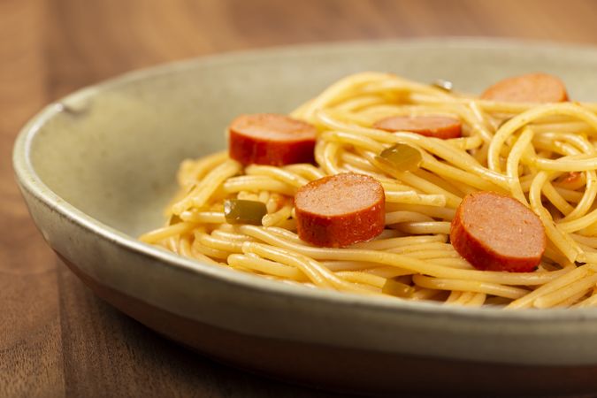 spaghetti pasta with sliced sausages and tomato sauce.