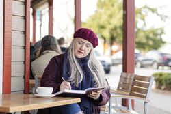 Woman writing down her ideas into a notebook