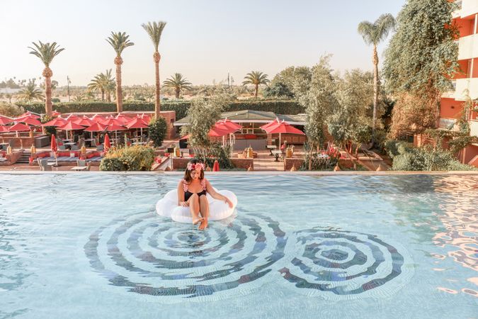 Woman wearing bikini sitting inflatable ring in pool