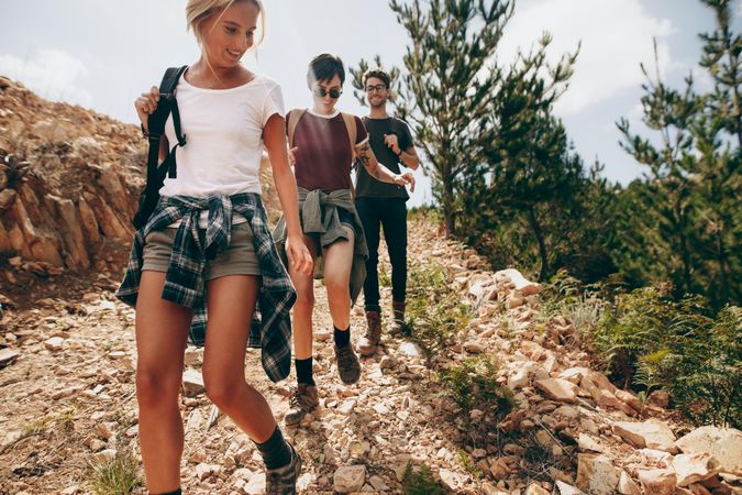 Friends hiking down a rugged hilly terrain
