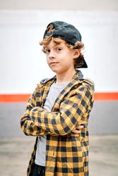 Child standing on street with crossed arms