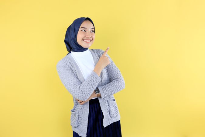 Asian Young Muslim Woman Wear Hijab Headscarf Smiling and Pointing Finger