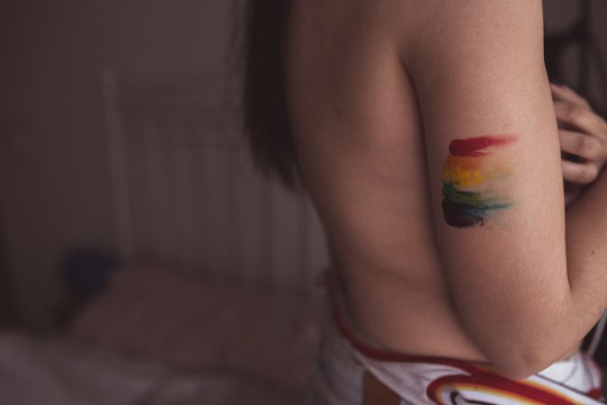 naked woman covering breast and drawing LGBTQIA symbol